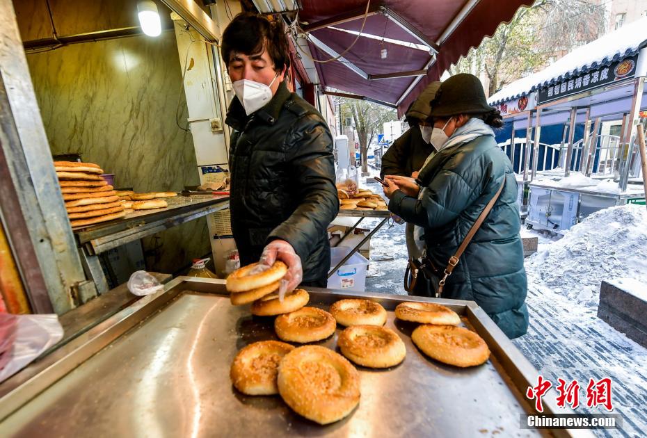 烏魯木齊市文化路，已開門營業(yè)的馕店吸引過往市民前來購買。 劉新 攝