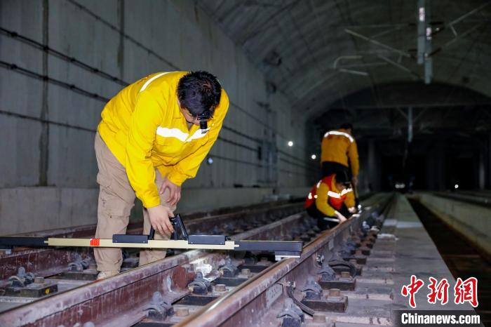 中國鐵路南寧局集團(tuán)有限公司南寧工務(wù)段職工使用道尺檢查吳圩機(jī)場(chǎng)高鐵站高鐵線路設(shè)備?！№f剛 攝